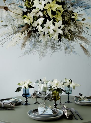 Floral decor with poinsettias and dried flowers hanging over festive table