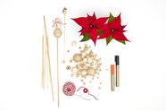 The materials for making this homemade decorative snowman flower stick are poinsettias, wooden sticks, wooden beads, hot glue and glue gun, pens and cotton string.