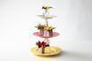 DIY upcycled cake stand made of tableware with poinsettias in tins and vintage jug and cups (on table)