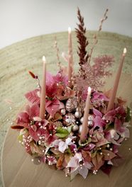 Adventskrans in schuim met gesneden kerststerren, gedroogde bloemen, spitskaarsen en kerstballen