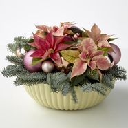 DIY arrangement of cut poinsettias, baubles and spruce foliage in a bowl