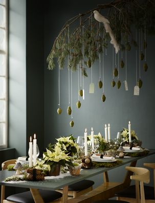 Natural table decor with dove, mushrooms, poinsettias, candles, fairy lights, cones and pine branch.