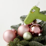 Collez les boules de Noël sur le les branches de sapin à l'aide d'un pistolet à colle.