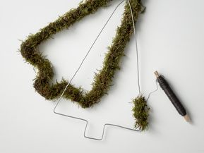 Moss is fixed with wire to DIY Christmas tree made from steel coat hanger