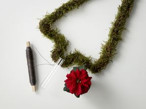 DIY upcycled Christmas tree made from coat hanger and moss with test tube, poinsettia and wire